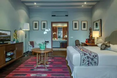 a bedroom with a bed and a table and a couch at Room & Vespa 3 - Relaxing Stay Center Seminyak in Seminyak