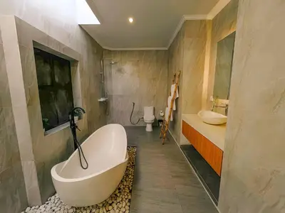 a bathroom with a tub and two sinks and a toilet at Villa Sinergi Seminyak 5 in Seminyak