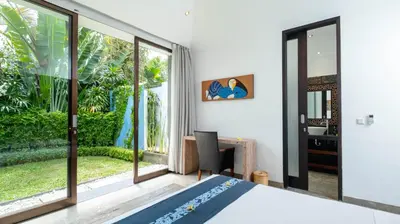 a bedroom with a bed and a large window at Villa Anjali Blue by Villa Finder in Seminyak