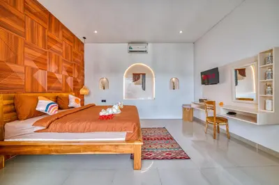 a bedroom with a large bed and a table at 3 Bed Cozy Mediterranean-Style Escape in Berawa in Canggu