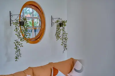 a mirror hanging on a wall next to a couch at 3 Bed Cozy Mediterranean-Style Escape in Berawa in Canggu