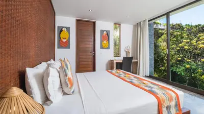 a bedroom with a white bed and a large window at Villa Anjali Orange by Villa Finder in Seminyak