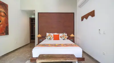 a bedroom with a bed with an orange pillow at Villa Anjali Orange by Villa Finder in Seminyak