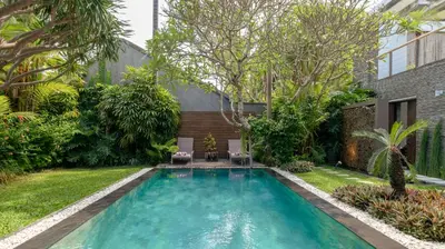 a swimming pool in the backyard of a house at Villa Anjali Green by Villa Finder in Seminyak