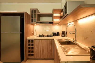 a kitchen with a sink and a stainless steel refrigerator at Twin Villas Cora & Zeno by Exotic Bali Properties in Seminyak