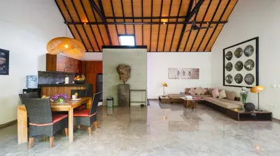 a living room with a table and a couch at Villa Anjali Purple by Villa Finder in Seminyak