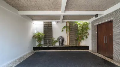 a hallway with a door and some plants at Villa Anjali Purple by Villa Finder in Seminyak