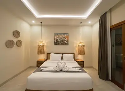 a bedroom with a bed with two towels on it at Villa Sinergi Seminyak 4 in Seminyak