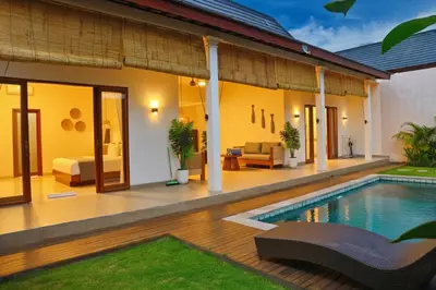 a villa with a swimming pool and a house at Villa Sinergi Seminyak 4 in Seminyak