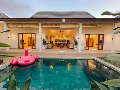 a house with a swimming pool in front of a house at Villa Sinergi Seminyak 4 in Seminyak
