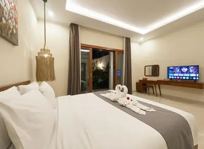 a bedroom with a white bed with a stuffed animal on it at Villa Sinergi Seminyak 4 in Seminyak