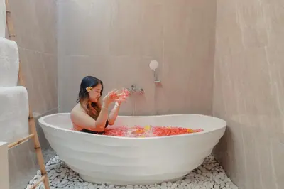 a woman sitting in a bath tub filled with bubbles at Villa Sinergi Seminyak 4 in Seminyak