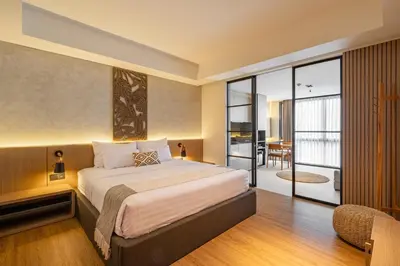a bedroom with a large bed and a balcony at de' Asasta Apartment Benoa N-511 in Nusa Dua