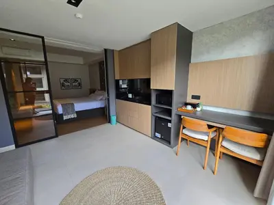 a room with a bed and a kitchen with a desk at de' Asasta Apartment Benoa N-511 in Nusa Dua
