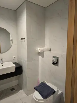 a white bathroom with a toilet and a sink at de Asasta Apartment Benoa E-105 in Nusa Dua