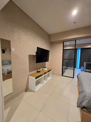 a bedroom with a bed and a tv on a wall at de Asasta Apartment Benoa E-105 in Nusa Dua