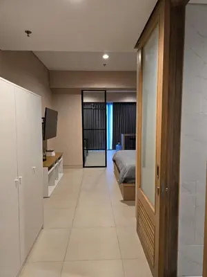 a bedroom with a bed and a desk with a television at de Asasta Apartment Benoa E-105 in Nusa Dua