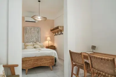 a bedroom with a bed and a table and chairs at Motel Molly Boutique Rooms Seminyak in Seminyak
