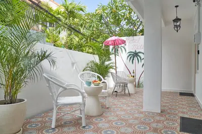 a patio with chairs and an umbrella and plants at Motel Molly Boutique Rooms Seminyak in Seminyak