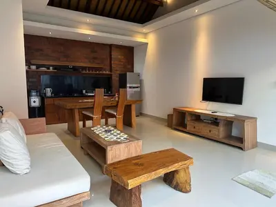 a living room with wooden furniture and a flat screen tv at Villa Lil'u in Seminyak