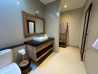 a bathroom with a sink and a toilet and a mirror at Villa Lil'u in Seminyak