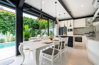 a kitchen and dining room with a white table and chairs at Villa Vantage 8, Umalas in Kerobokan