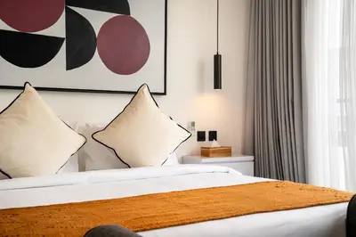 a bedroom with a bed with white sheets and pillows at Villa Vantage 8, Umalas in Kerobokan