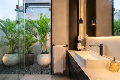 a bathroom with a sink and two potted plants at Villa Vantage 8, Umalas in Kerobokan