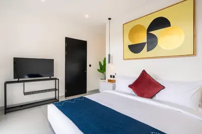 a bedroom with a bed and a flat screen tv at Villa Vantage 8, Umalas in Kerobokan