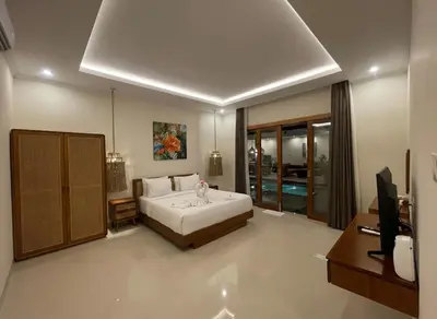 a bedroom with a bed and a tv in it at Villa Sinergi Seminyak 3 in Seminyak