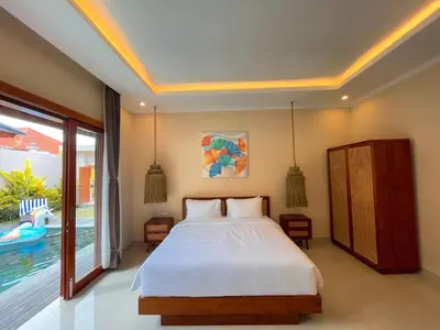 a bedroom with a bed and a pool at Villa Sinergi Seminyak 3 in Seminyak