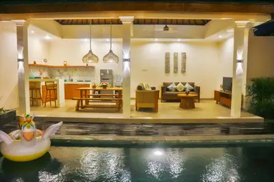 a house with a swimming pool and a living room at Villa Sinergi Seminyak 3 in Seminyak