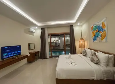 a bedroom with a white bed and a television at Villa Sinergi Seminyak 3 in Seminyak