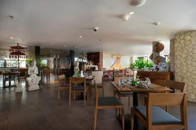 a dining room with wooden tables and chairs at d'primahotel Petitenget Seminyak 2 in Seminyak