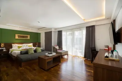 a hotel room with a bed and a living room at d'primahotel Petitenget Seminyak 2 in Seminyak
