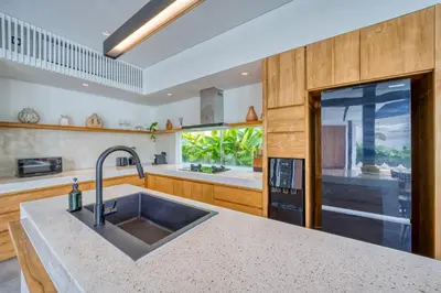 a kitchen with a sink and a large window at Luxury Industrial-Style 2BR Villa Kirma Near the Beach in Canggu