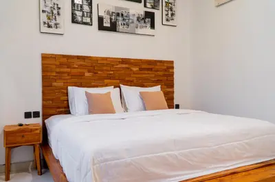 a bedroom with a large white bed with a brick wall at Danbi Villa Bali By Bali Cabin in Canggu