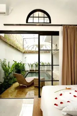 a bedroom with a bed and a swimming pool at Danbi Villa Bali By Bali Cabin in Canggu