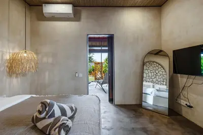a bedroom with a bed and a tv and a mirror at Brand New 4BR Villa with Pool, Sauna & Fire pit close to Nusa Dua and Uluwatu in Jimbaran