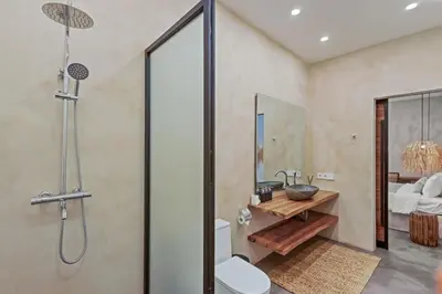 a bathroom with a shower and a toilet and a sink at Brand New 4BR Villa with Pool, Sauna & Fire pit close to Nusa Dua and Uluwatu in Jimbaran