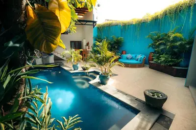 a large swimming pool in a room with plants at Bali Akasa Villa in Seminyak