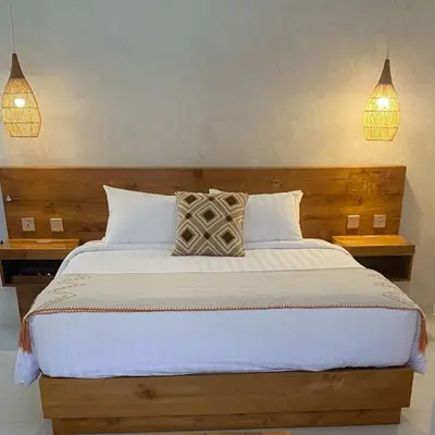 a bedroom with a large bed with two lamps at Santai Suites Nusa Dua-Child Free in Nusa Dua