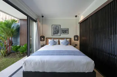 a bedroom with a large bed and a large window at Twin Villas Drupadi 8BR Seminyak by Exotic Bali Properties in Seminyak