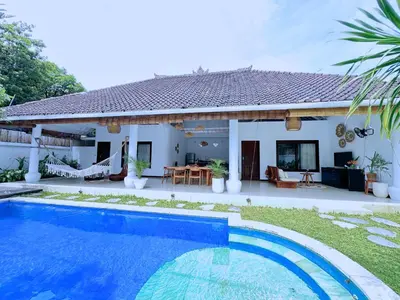 a villa with a swimming pool in front of a house at A strategic 2 bedroom villa in seminyak in Seminyak