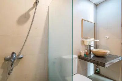 a bathroom with a shower with a toilet and a sink at Villa Azure 3 - Tropical 4-Bedroom Pool Villa Near Seminyak in Seminyak