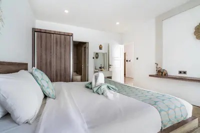 a bedroom with a large white bed with a wooden headboard at Villa Azure 2 - Master Suite in shared Pool Villa in Seminyak