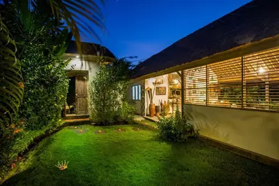 a backyard of a house with a green yard at Villa Damai Manis in Seminyak