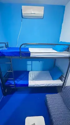 a room with two bunk beds with blue walls at Santorini House in Bali Near Airport in Kuta