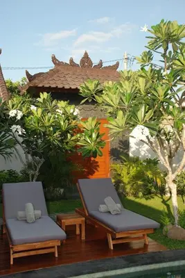 two chairs sitting on a deck in a resort at The Clovewood Villa in Seminyak