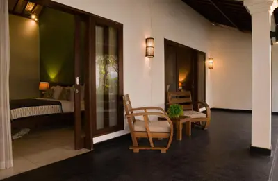 a room with a bed and two chairs and a table at The Clovewood Villa in Seminyak